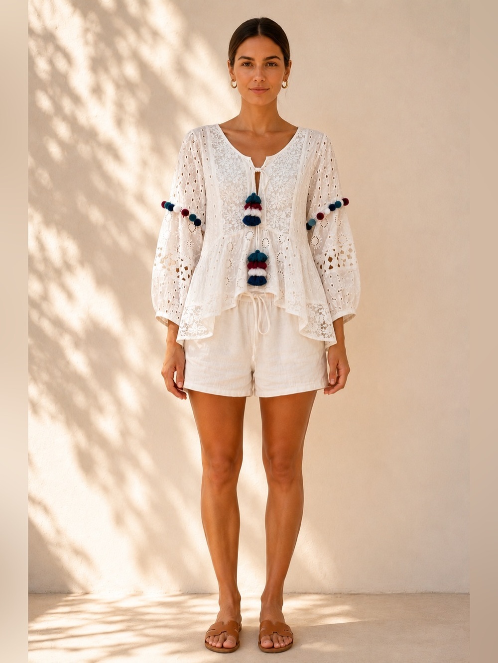 Misa Los Angeles white eyelet lace up top with tassel and pom pom details. Med
